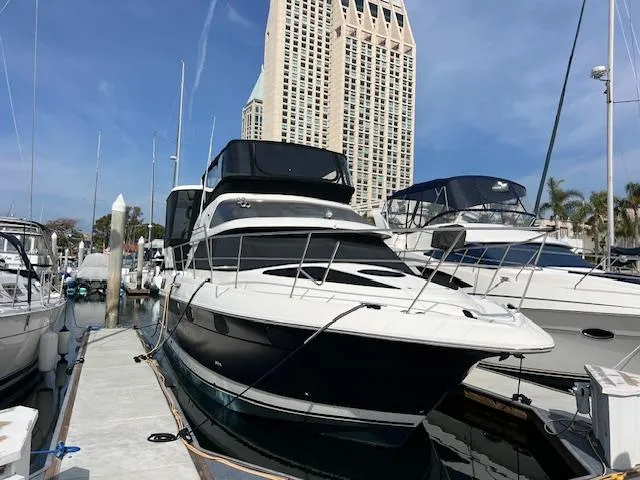 Slide: The Image of 1995 Cruisers Yachts 3650 ACMY docked at marina with skyscraper backdrop. - 9