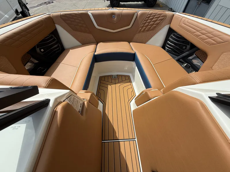 Slide: The Image of 2024 Nautique G21 boat interior with tan leather seating and wood flooring. - 12