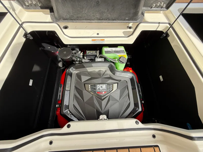 Slide: The Image of 2024 Nautique G21 engine compartment with PCM engine, open hatch view. - 16