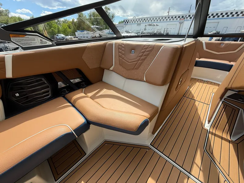 Slide: The Image of 2024 Nautique G21 boat interior with tan and white seating, wood-style flooring, and modern design. - 9