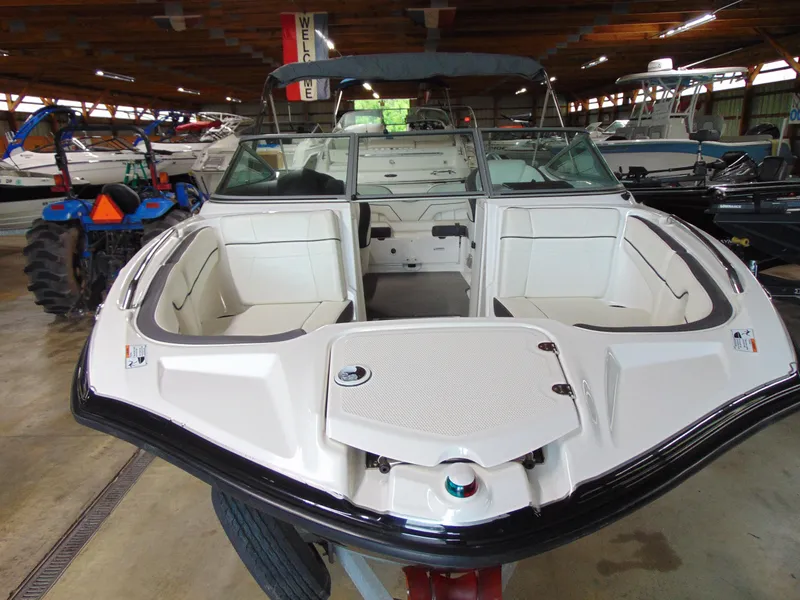 Slide: The Image of 2014 Yamaha Boats SX210 in showroom, featuring spacious seating and sleek design. - 3