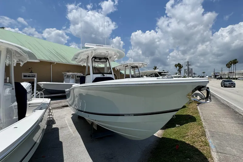 Slide: The Image of 2025 Regulator 28 boat displayed outdoors under a partly cloudy sky. - 2