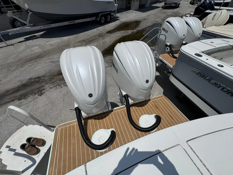 Slide: The Image of Twin Yamaha outboard engines on a 2025 Regulator 28 boat, docked on a sunny day. - 3