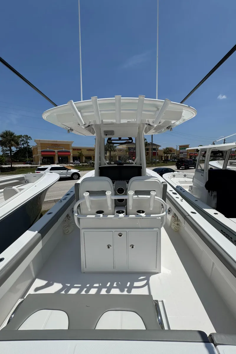 Slide: The Image of 2025 Regulator 28 boat interior with dual seats and console under clear blue sky. - 5