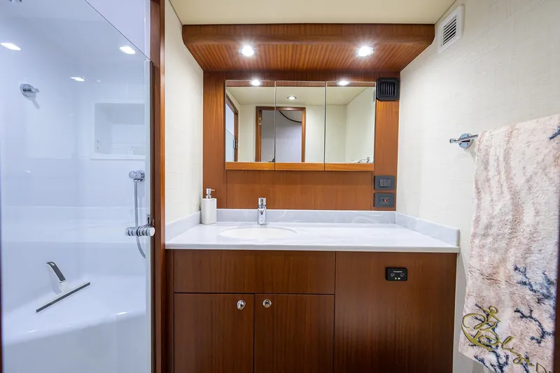 Slide: The Image of Luxurious bathroom in 2022 F&S 58 Custom Carolina yacht with modern fixtures and wooden cabinetry. - 25
