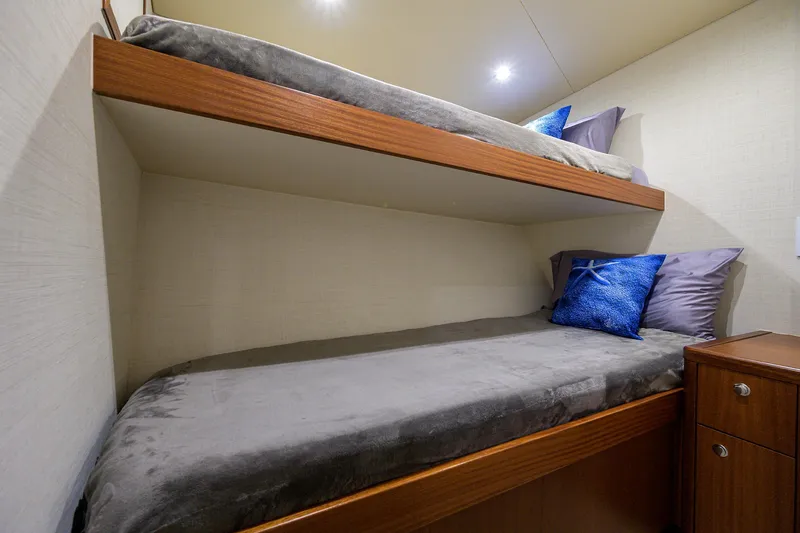 Slide: The Image of Bunk beds in 2022 F&S 58 Custom Carolina yacht cabin with blue pillows. - 27
