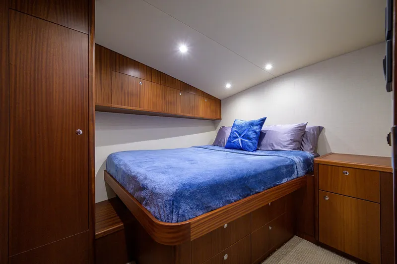 Slide: The Image of 2022 F&S 58 Custom Carolina yacht cabin with wooden cabinetry and blue bedding. - 28
