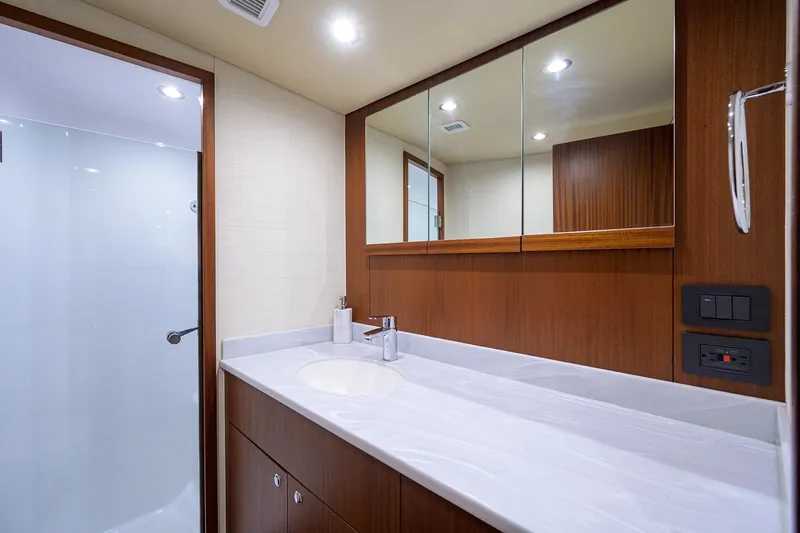 Slide: The Image of Luxurious bathroom in 2022 F&S 58 Custom Carolina yacht with modern fixtures and wooden cabinetry. - 30