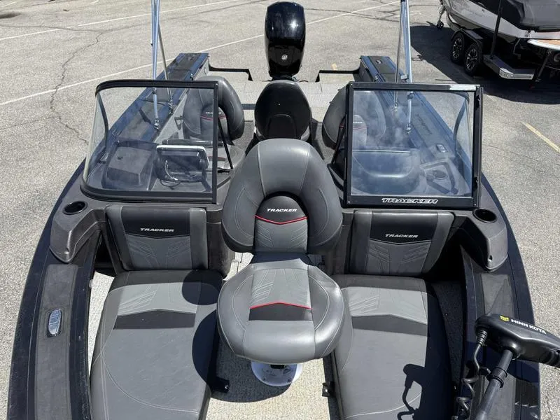 Slide: The Image of 2023 Tracker Targa 18 boat interior with seating and windshield, parked on pavement. - 10