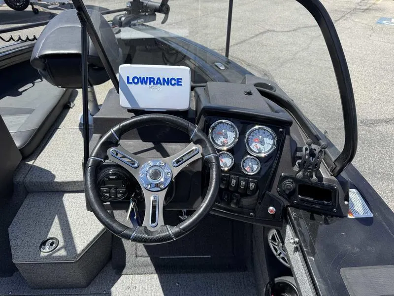 Slide: The Image of 2023 Tracker Targa 18 boat dashboard with steering wheel and Lowrance navigation system. - 2