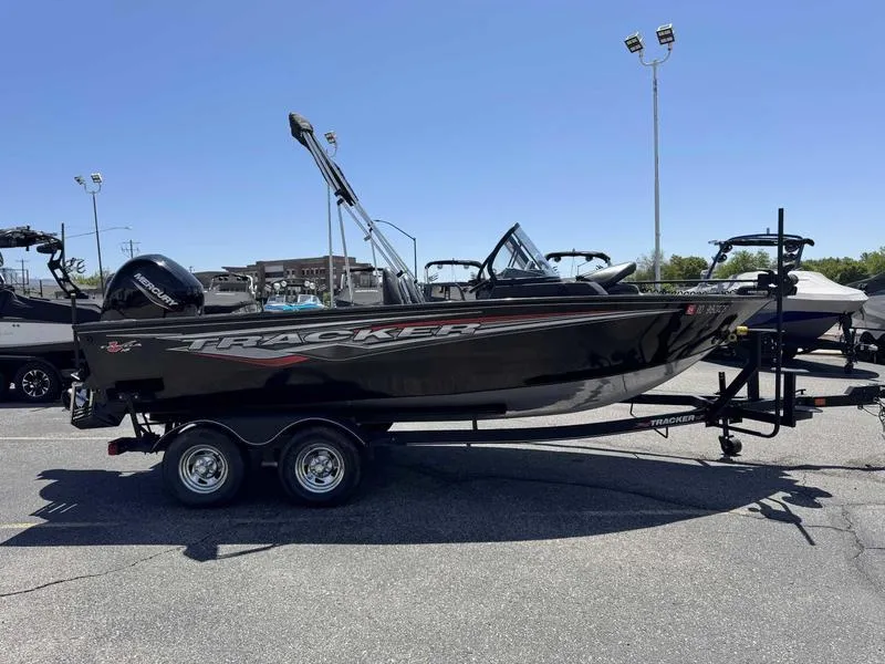 Slide: The Image of 2023 Tracker Targa 18 boat on trailer in parking lot, clear sky background. - 7