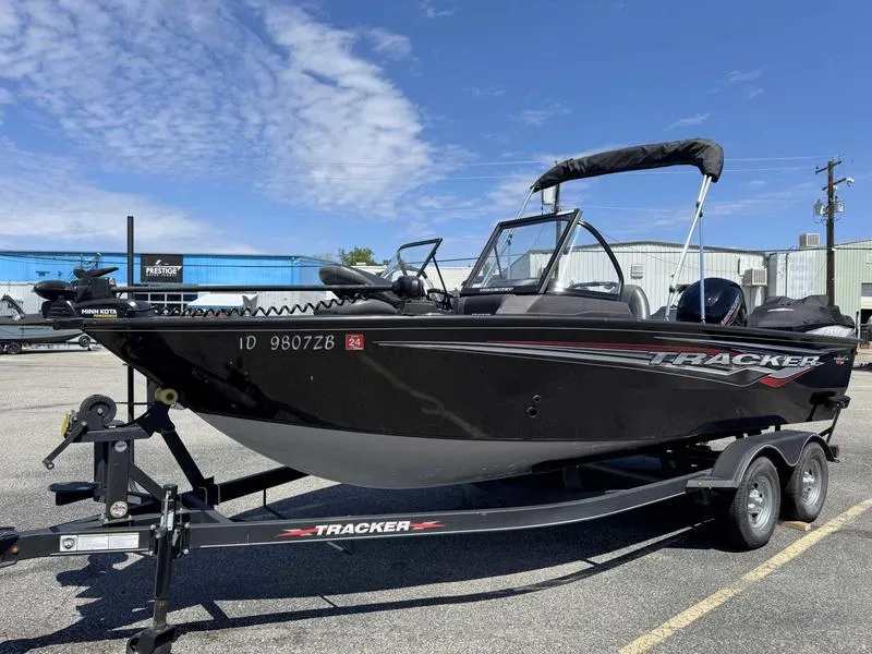 Slide: The Image of 2023 Tracker Targa 18 boat on trailer, parked outdoors under blue sky. - 9