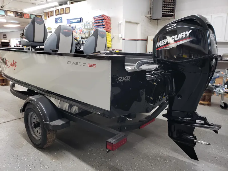 Slide: The Image of 2024 Alumacraft Classic 165cs boat with Mercury engine in showroom. - 1
