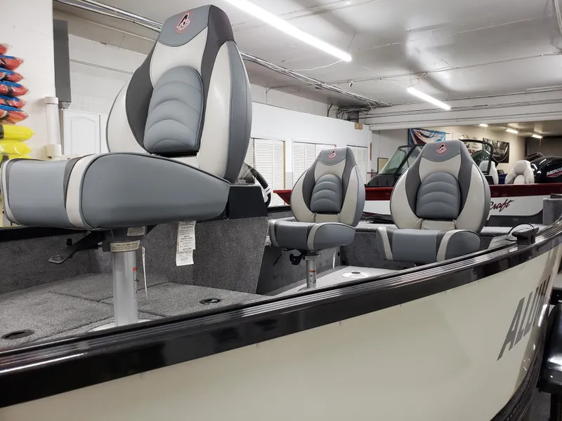 Slide: The Image of 2024 Alumacraft Classic 165cs boat interior with cushioned seats in showroom. - 3
