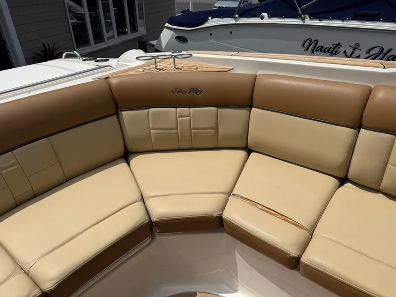 Slide: The Image of 2015 Sea Ray 350 SLX boat with tan leather seating in a sunny marina. - 11