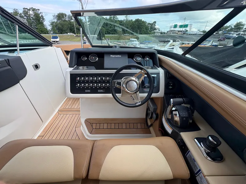 Slide: The Image of 2015 Sea Ray 350 SLX boat cockpit with steering wheel and control panel. - 15