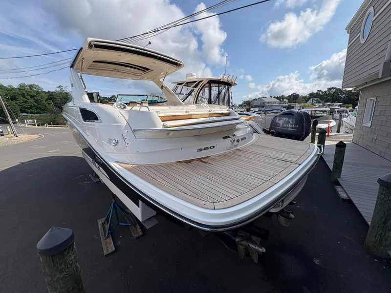 Slide: The Image of 2015 Sea Ray 350 SLX boat docked, showcasing sleek design and spacious deck. - 4