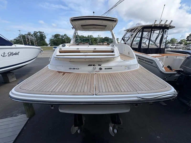 Slide: The Image of 2015 Sea Ray 350 SLX boat with spacious deck, docked alongside other vessels. - 5