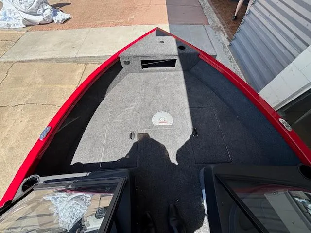 Slide: The Image of 2025 Crestliner 1750 Hawk boat interior with red trim and carpeted deck. - 11