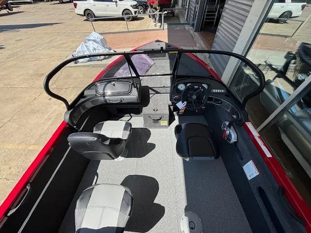 Slide: The Image of 2025 Crestliner 1750 Hawk boat interior with seating and dashboard, parked outdoors. - 16