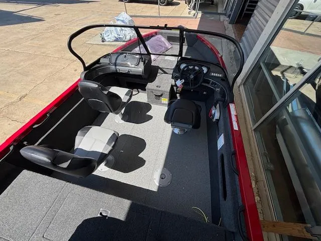 Slide: The Image of 2025 Crestliner 1750 Hawk boat interior with seating and steering console, docked outdoors. - 17