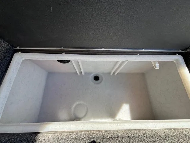 Slide: The Image of 2025 Crestliner 1750 Hawk livewell, empty and open, showcasing interior design and drainage. - 2