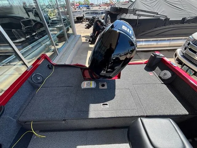 Slide: The Image of 2025 Crestliner 1750 Hawk boat interior with motor, red accents, and seating. - 4