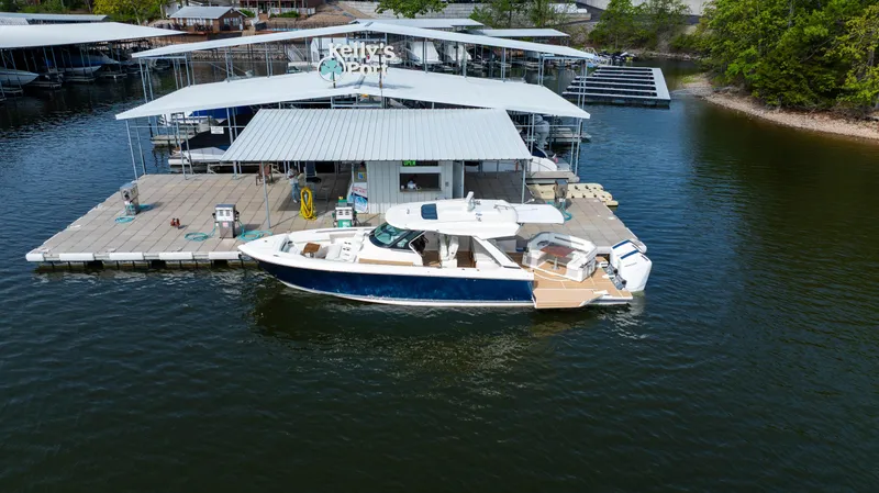 Slide: The Image of 2024 Tiara Yachts 43 LS docked at a marina with covered slips. - 2