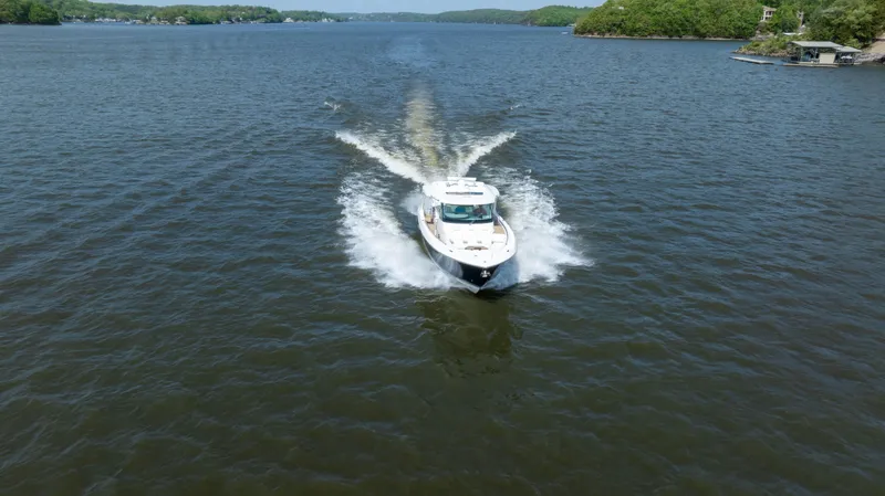 Slide: The Image of 2024 Tiara Yachts 43 LS cruising on a scenic lake. - 34