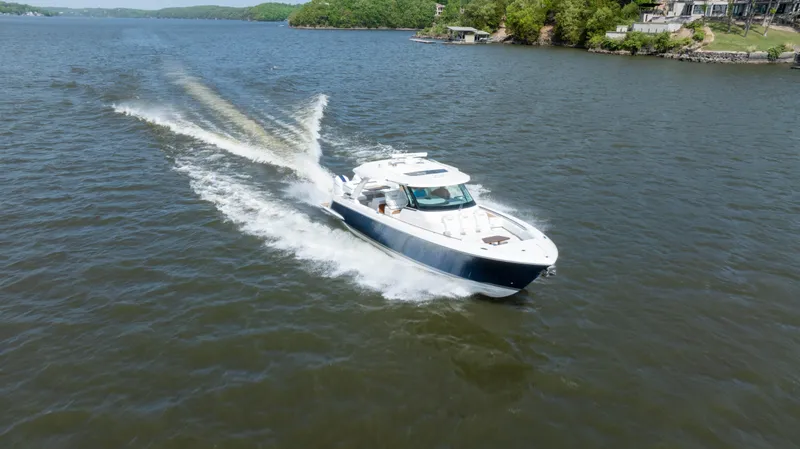 Slide: The Image of 2024 Tiara Yachts 43 LS cruising on a scenic lake. - 35