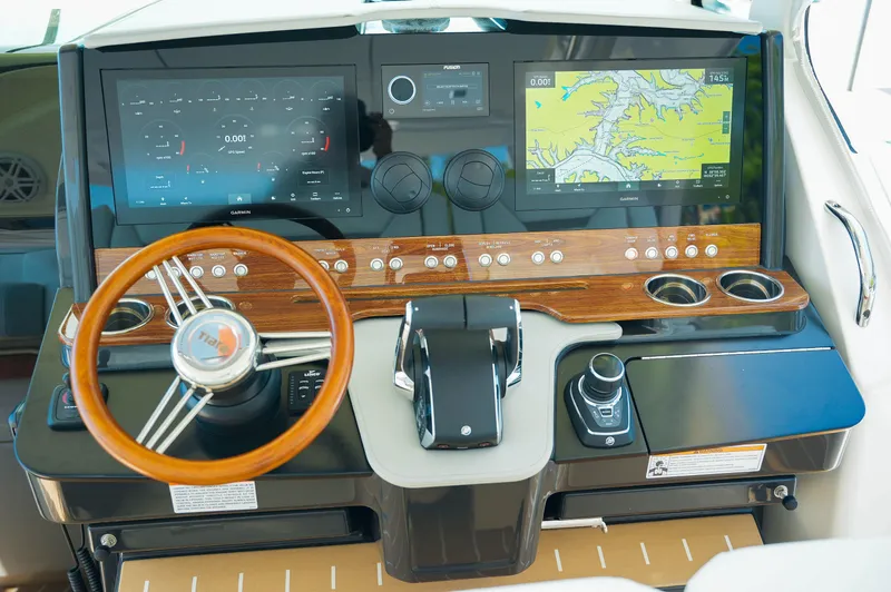 Slide: The Image of 2024 Tiara Yachts 43 LS helm with advanced navigation displays and wooden steering wheel. - 48