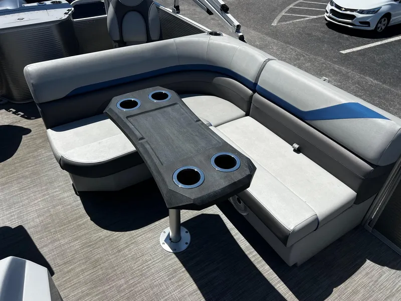 Slide: The Image of 2021 Bennington SX 21 SFXAPG boat interior with gray seating and table with cup holders. - 10