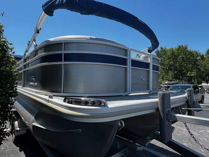 Slide: The Image of 2021 Bennington SX 21 SFXAPG pontoon boat on trailer under clear blue sky. - 4