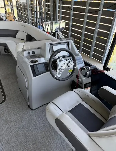 Slide: The Image of 2022 Harris Cruiser 230 boat interior with steering console and seating. - 12