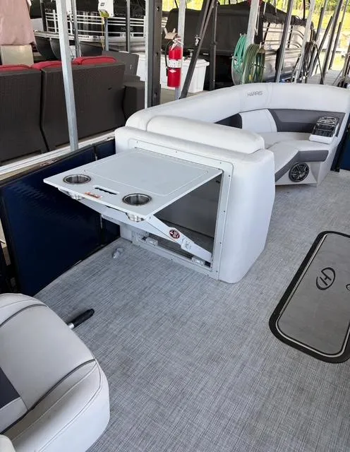 Slide: The Image of 2022 Harris Cruiser 230 boat interior with foldable table and cup holders. - 17