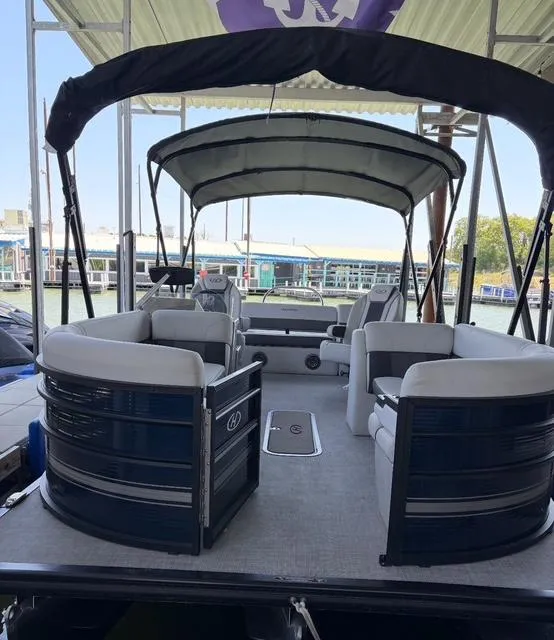 Slide: The Image of 2022 Harris Cruiser 230 pontoon boat with canopy, docked at marina. - 9
