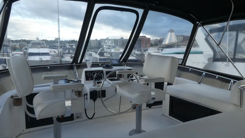 Slide: The Image of 1993 Ocean Alexander 440 Sundeck CPMY cockpit with marina view, featuring helm and seating. - 11