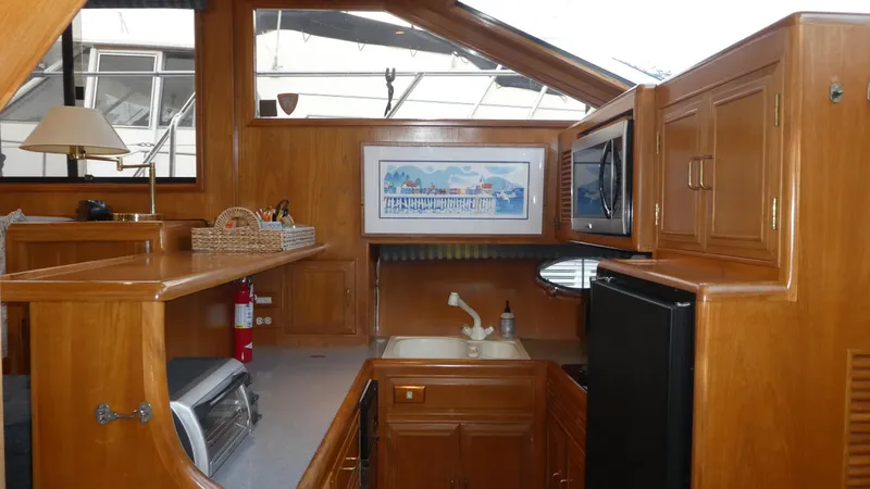 Slide: The Image of Interior of 1993 Ocean Alexander 440 Sundeck CPMY with wooden cabinetry and kitchenette. - 24