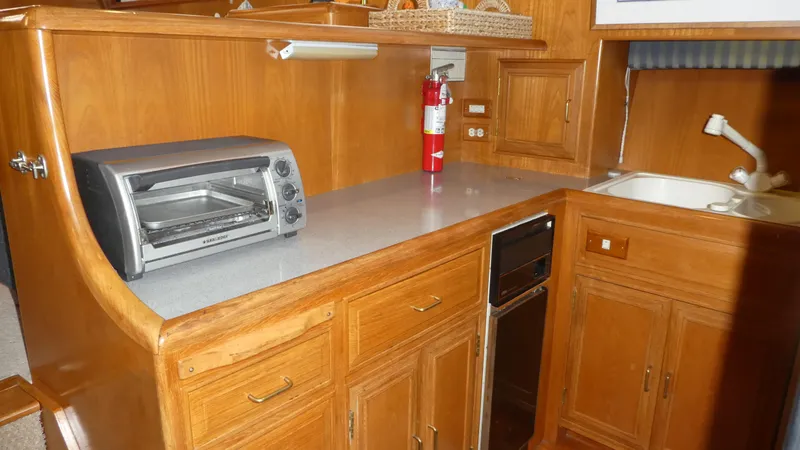 Slide: The Image of 1993 Ocean Alexander 440 Sundeck CPMY kitchen with wooden cabinets and countertop appliances. - 26