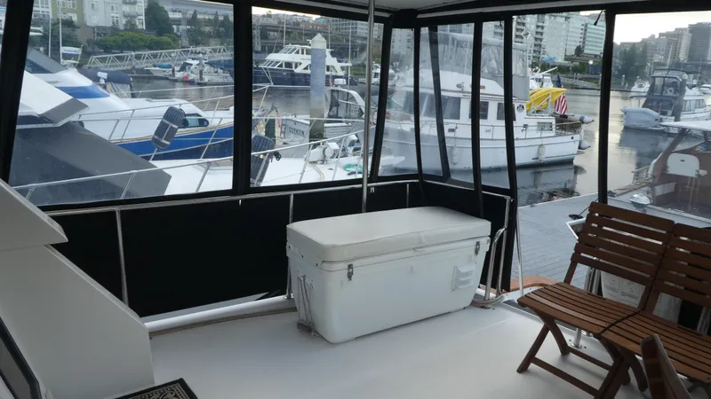 Slide: The Image of 1993 Ocean Alexander 440 Sundeck CPMY yacht interior with marina view, featuring seating and storage. - 5