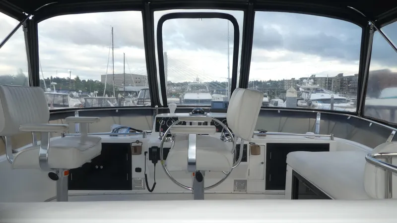 Slide: The Image of 1993 Ocean Alexander 440 Sundeck CPMY cockpit with marina view, featuring helm and seating. - 9
