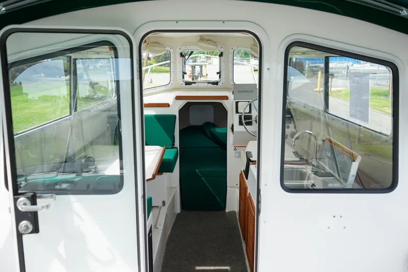 Slide: The Image of Interior view of 2021 C-Dory 25' Cruiser boat with green seating and modern amenities. - 11