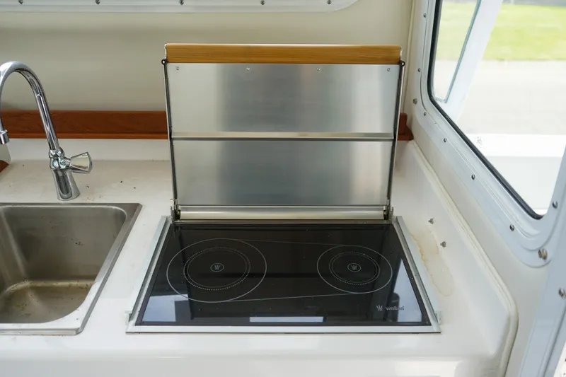 Slide: The Image of Compact kitchen in 2021 C-Dory 25' Cruiser with stove and sink. - 13