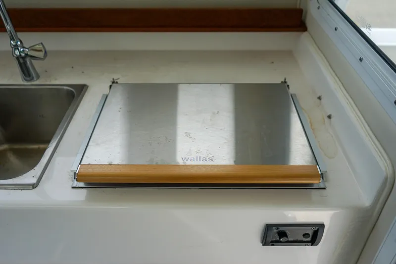Slide: The Image of C-Dory 25' Cruiser 2021 kitchen area with sink and Wallas stove. - 14