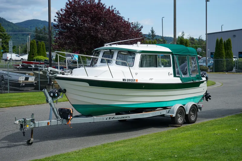 Slide: The Image of 2021 C-Dory 25' Cruiser on trailer, green and white, parked outdoors. - 20