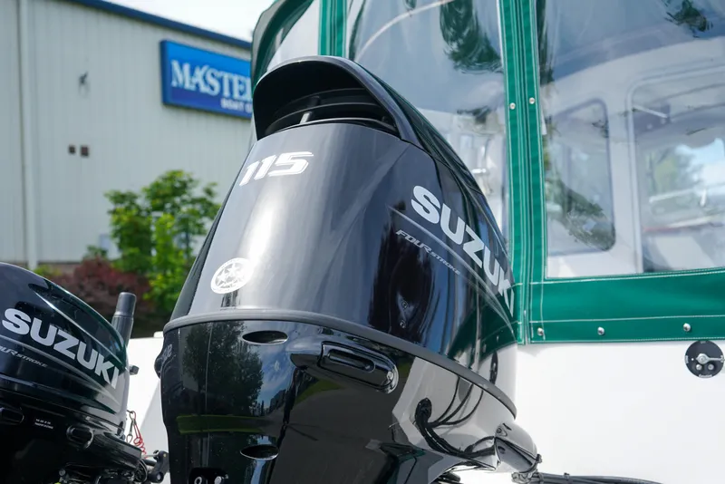 Slide: The Image of Suzuki 115 outboard motor on 2021 C-Dory 25' Cruiser boat, outdoor setting. - 5