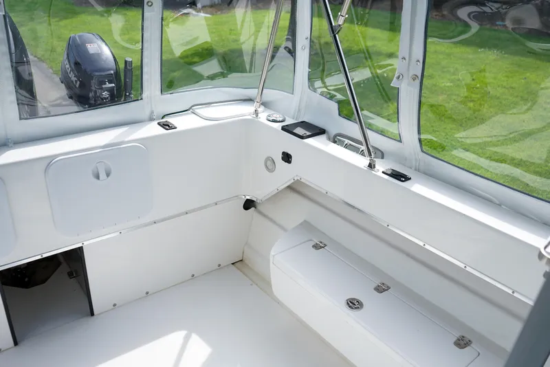 Slide: The Image of 2021 C-Dory 25' Cruiser interior with white seating and windows, showcasing spacious design. - 8