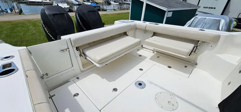 Slide: The Image of 2016 Boston Whaler 285 Conquest boat interior with foldable seating and twin engines. - 12
