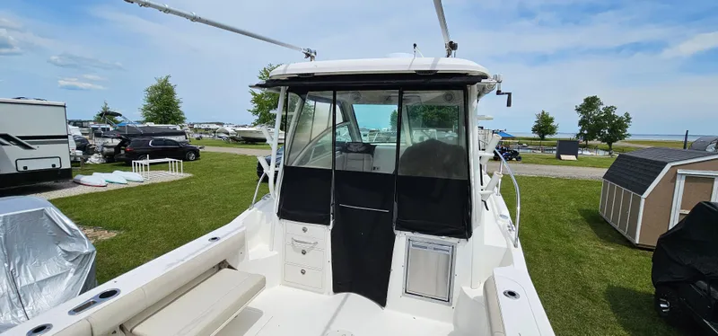 Slide: The Image of 2016 Boston Whaler 285 Conquest boat docked on grassy area with clear sky. - 14