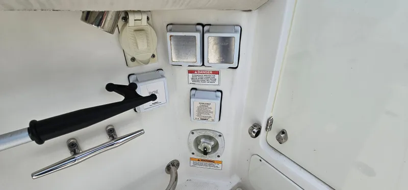 Slide: The Image of Control panel on a 2016 Boston Whaler 285 Conquest boat, featuring switches and safety labels. - 15
